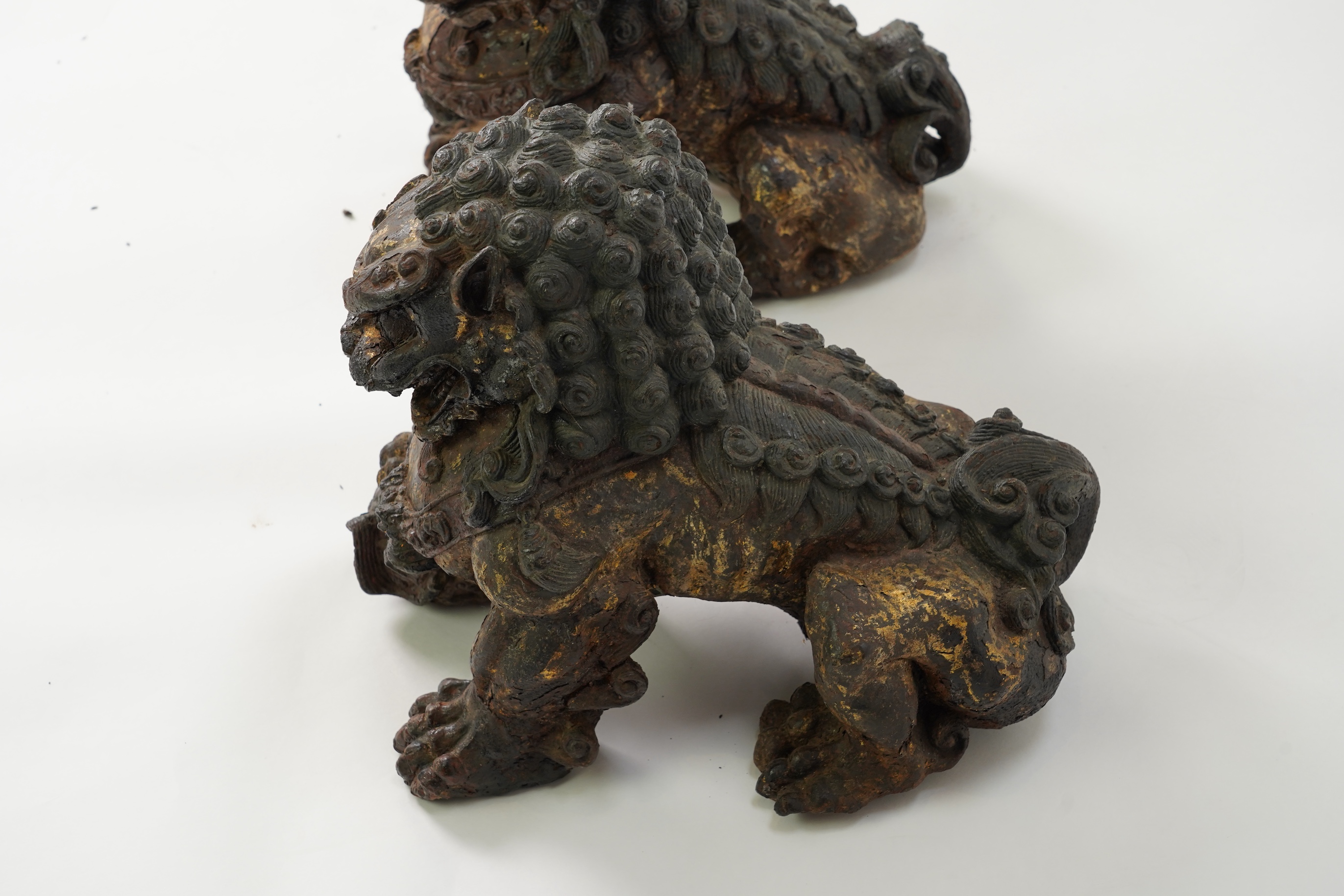 A pair of large Chinese polychrome lacquered cast iron models of lion temple guardians, Qing dynasty